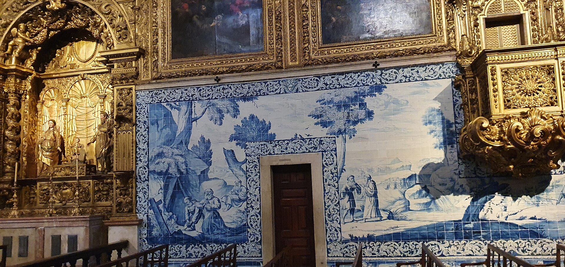 Blue-and-white azulejos surround a doorway beside gilded carving and a side altar inside Lisbon's Madre de Deus church.