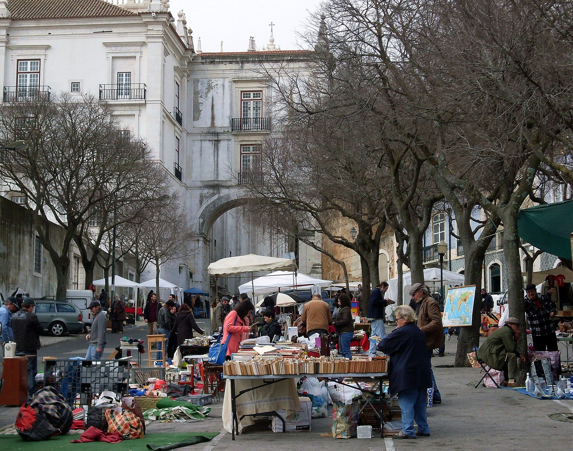 Books, crockery and assorted secondhand goods fill Feira da Ladra beneath the white Arco Grande de Cima in Lisbon.