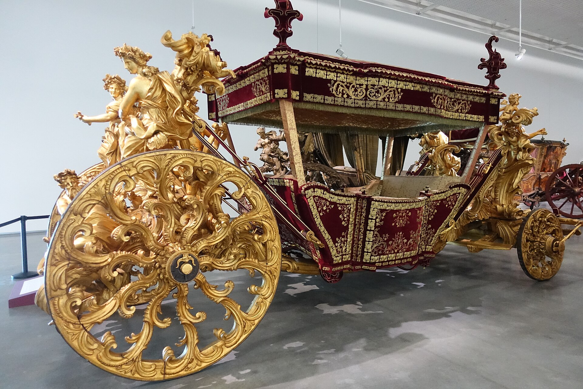 The Coach of the Oceans at Lisbon's National Coach Museum combines an ornate gilded wheel, sculpted figures and deep red fabric panels.
