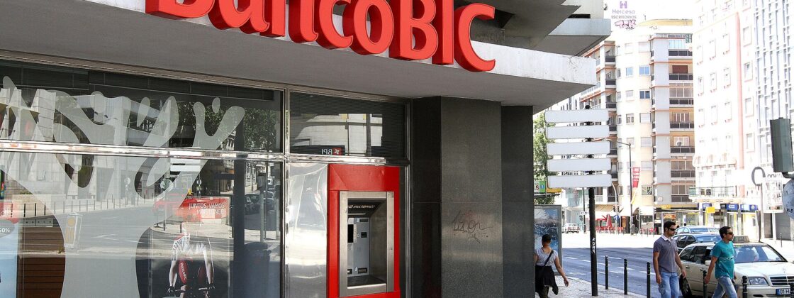 A Multibanco cash machine sits beside the BancoBIC storefront in Lisbon’s Saldanha district as pedestrians pass on the pavement.