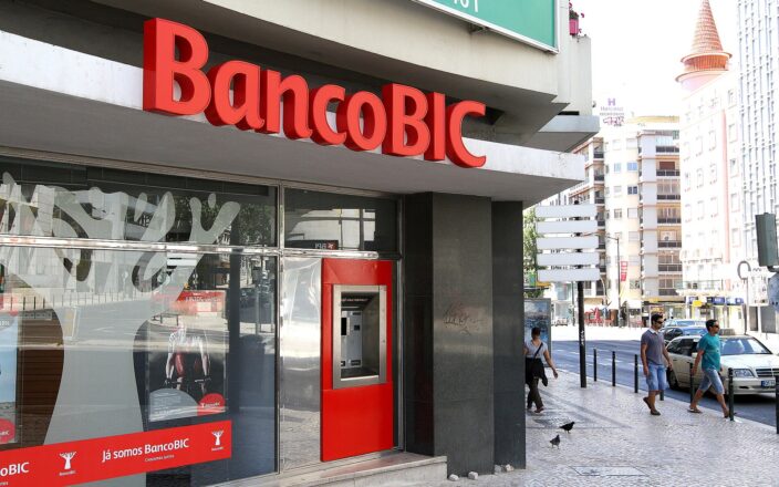 A Multibanco cash machine sits beside the BancoBIC storefront in Lisbon’s Saldanha district as pedestrians pass on the pavement.